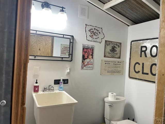 bathroom featuring visible vents, a sink, and toilet