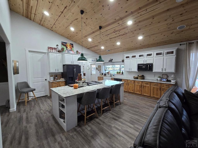 kitchen with decorative light fixtures, brown cabinetry, white cabinets, a kitchen island, and black appliances