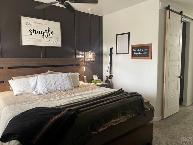 carpeted bedroom featuring a barn door