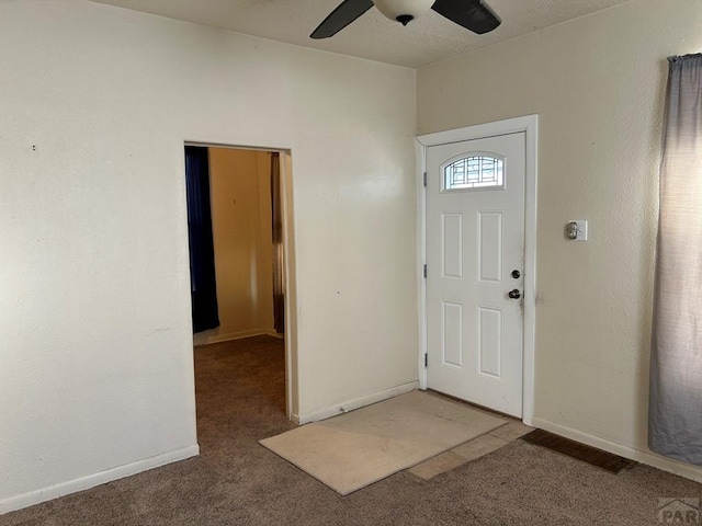 entrance foyer featuring carpet floors, a ceiling fan, and baseboards