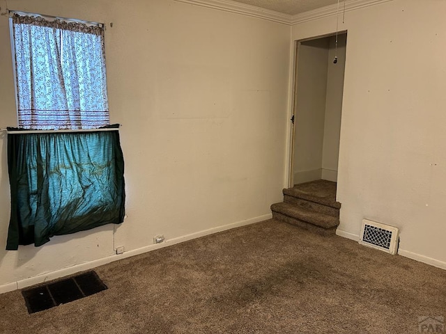 unfurnished living room featuring carpet floors, baseboards, visible vents, and crown molding