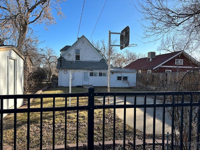 rear view of house with fence private yard and a lawn