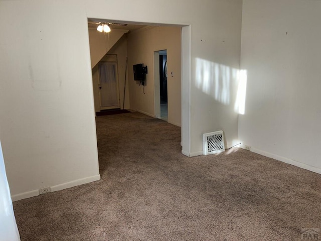 empty room with a ceiling fan, baseboards, visible vents, and carpet flooring