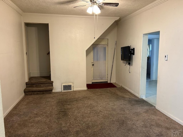 spare room featuring a textured ceiling, visible vents, stairs, ornamental molding, and dark colored carpet