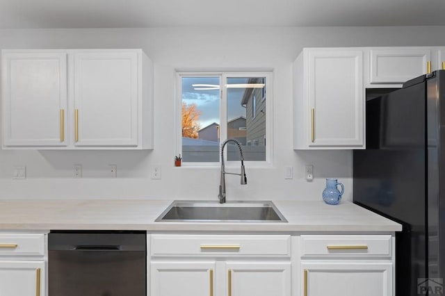 2200 Meadowlark Ln, Pueblo, CO 81008 - kitchen with freestanding refrigerator, dishwashing machine, white cabinetry, and a sink