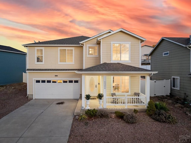 2200 Meadowlark Ln, Pueblo, CO 81008 - traditional-style home with fence, a shingled roof, concrete driveway, an attached garage, and covered porch
