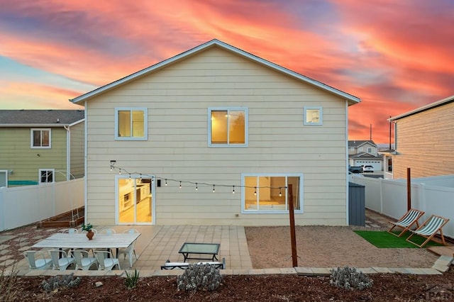 2200 Meadowlark Ln, Pueblo, CO 81008 - back of house at dusk featuring a fenced backyard and a patio