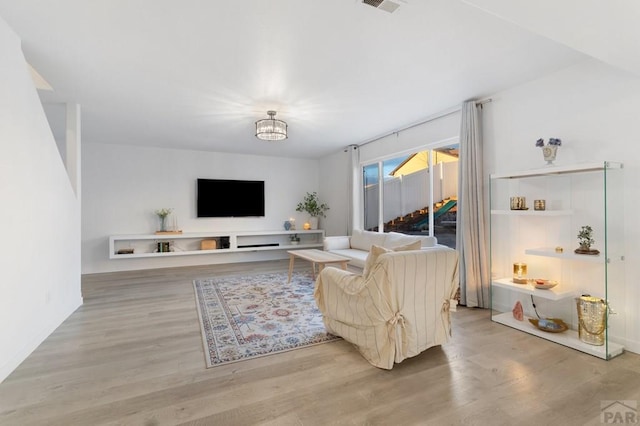 2200 Meadowlark Ln, Pueblo, CO 81008 - living area with wood finished floors, visible vents, baseboards, and an inviting chandelier