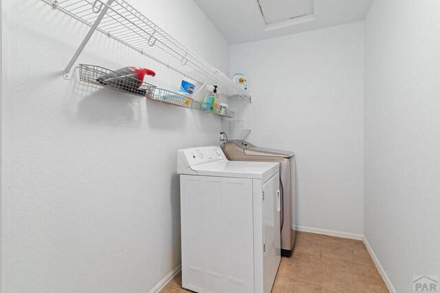 2200 Meadowlark Ln, Pueblo, CO 81008 - laundry room with light tile patterned floors, baseboards, washer and dryer, and laundry area