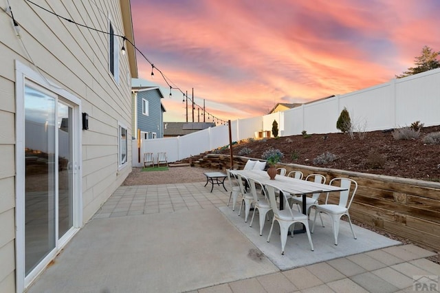 2200 Meadowlark Ln, Pueblo, CO 81008 - patio terrace at dusk featuring outdoor dining area and a fenced backyard