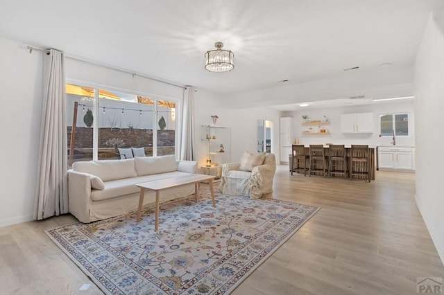 2200 Meadowlark Ln, Pueblo, CO 81008 - living area with light wood-style flooring, baseboards, and a chandelier