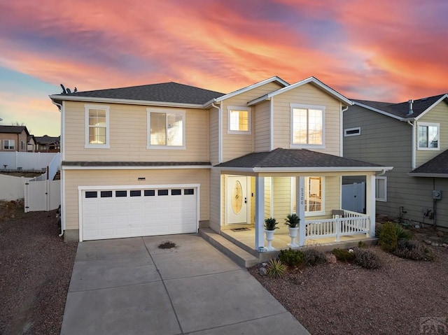 2200 Meadowlark Ln, Pueblo, CO 81008 - traditional home with fence, an attached garage, driveway, covered porch, and roof with shingles