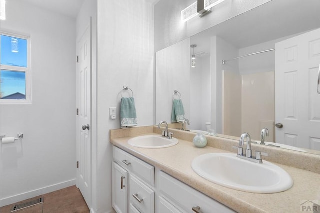 2200 Meadowlark Ln, Pueblo, CO 81008 - bathroom with double vanity, visible vents, walk in shower, and a sink