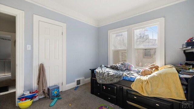 bedroom featuring ornamental molding, dark colored carpet, visible vents, and baseboards