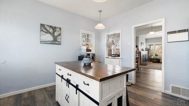 interior space featuring dark wood-style floors, baseboards, and visible vents