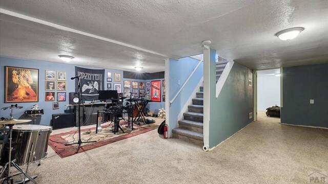 basement with a textured ceiling, stairway, and carpet flooring