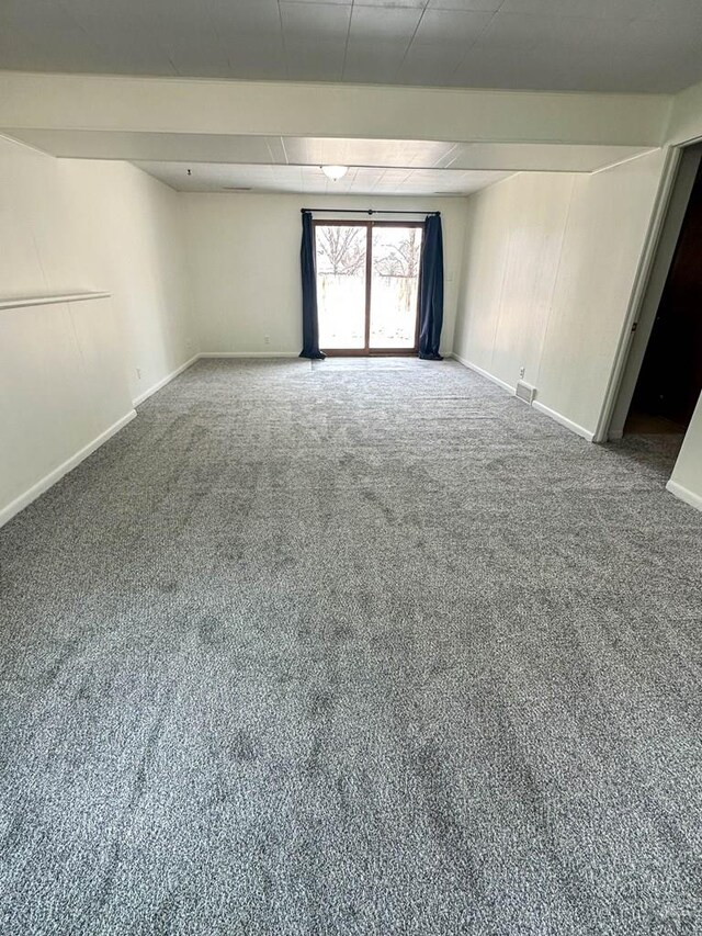 carpeted empty room featuring baseboards