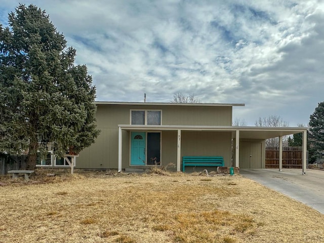 view of front of house featuring a carport, fence, and driveway