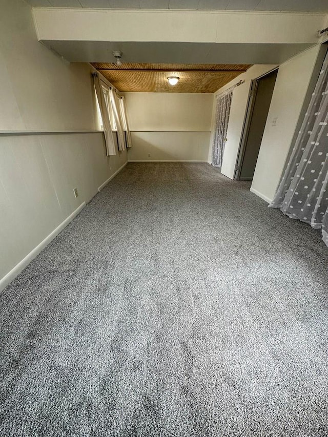 carpeted empty room featuring baseboards