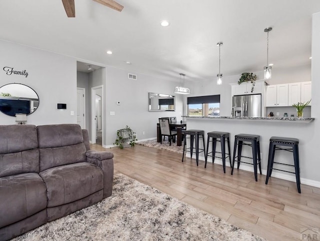 living area with recessed lighting, light wood-type flooring, baseboards, and ceiling fan
