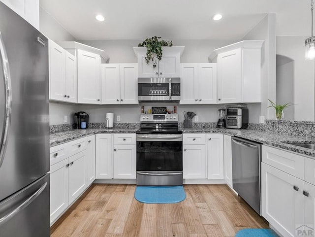 kitchen featuring stainless steel appliances, recessed lighting, light wood finished floors, and white cabinets