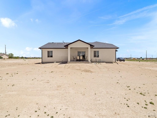rear view of property featuring a patio and stucco siding