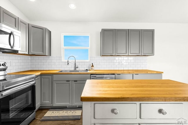 1090 E Linda Ave, Pueblo West, CO 81007 - kitchen with wood counters, appliances with stainless steel finishes, a sink, gray cabinets, and backsplash