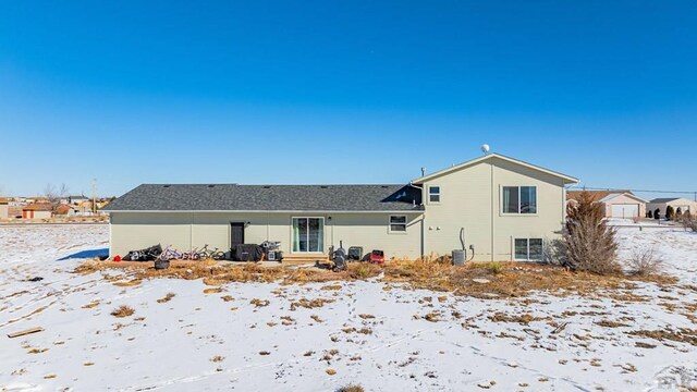 view of snow covered rear of property