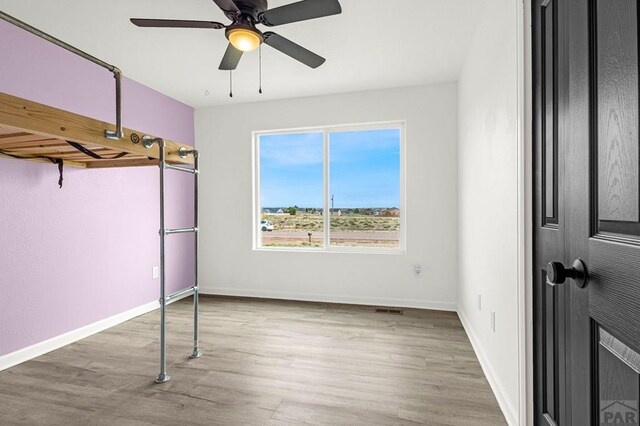 1090 E Linda Ave, Pueblo West, CO 81007 - unfurnished bedroom featuring wood finished floors, baseboards, and ceiling fan