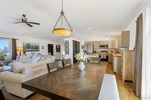 dining area featuring light wood finished floors, ceiling fan, vaulted ceiling, and recessed lighting