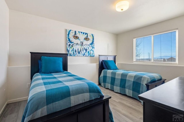 bedroom with light wood-style flooring and baseboards