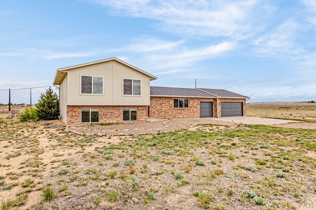 1090 E Linda Ave, Pueblo West, CO 81007 - tri-level home with a garage, brick siding, concrete driveway, and fence