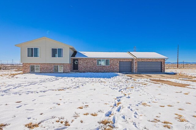 tri-level home with an attached garage and brick siding