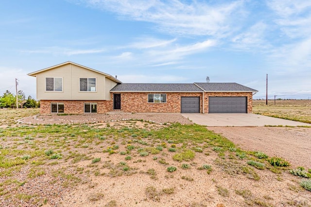 1090 E Linda Ave, Pueblo West, CO 81007 - tri-level home featuring concrete driveway, a garage, and brick siding