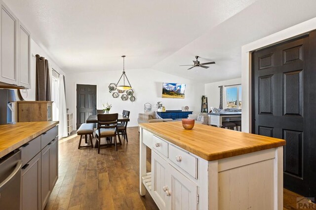 kitchen with wood counters, white cabinetry, open floor plan, a center island, and pendant lighting