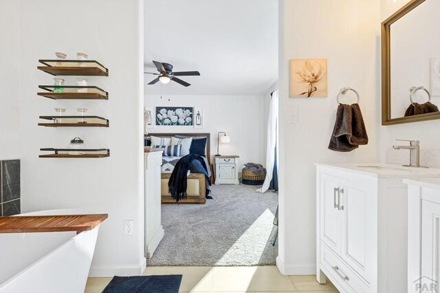 bathroom featuring a ceiling fan, a freestanding tub, connected bathroom, and vanity