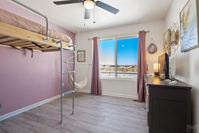 unfurnished bedroom featuring light wood-style floors, baseboards, and a ceiling fan