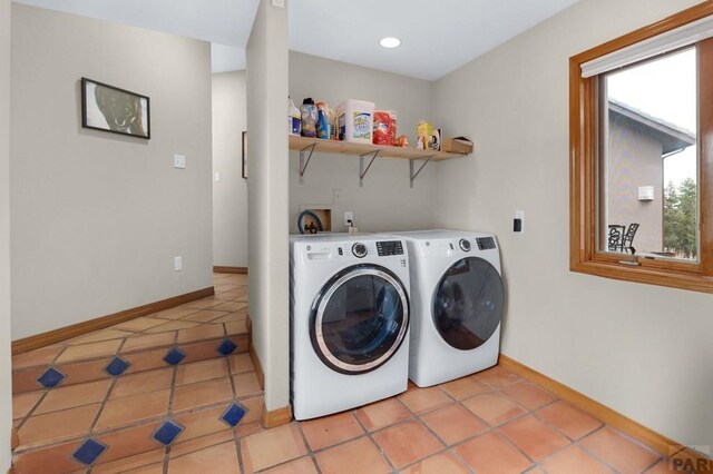 washroom featuring light tile patterned floors, baseboards, laundry area, and washer and dryer