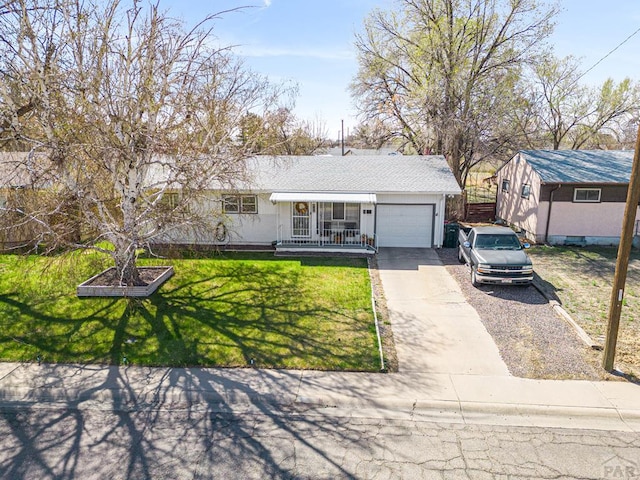 view of front of house featuring a shingled roof, an attached garage, driveway, and a front lawn