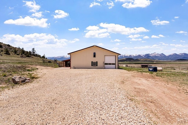 1800 Oak Grove Cir, Westcliffe, CO 81252 - view of side of home with a mountain view, a detached garage, an outbuilding, and driveway