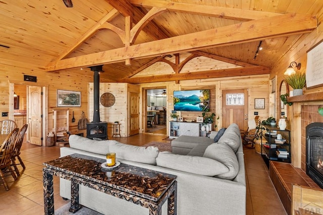 1800 Oak Grove Cir, Westcliffe, CO 81252 - tiled living area with a wood stove, wood walls, wood ceiling, and a tiled fireplace