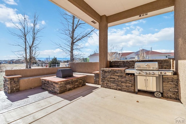 view of patio featuring visible vents, fence, and exterior kitchen