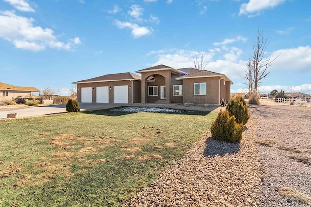 view of front facade featuring a front lawn, driveway, an attached garage, and stucco siding