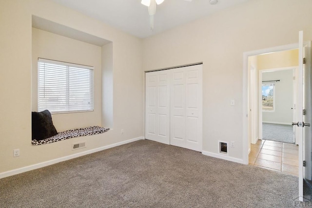 unfurnished bedroom with light tile patterned floors, a closet, light colored carpet, visible vents, and baseboards