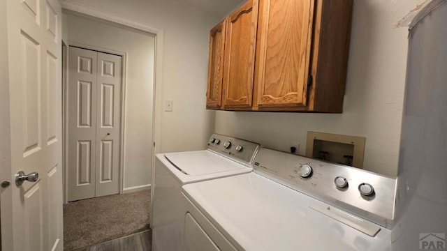 laundry area featuring carpet floors, cabinet space, and washer and clothes dryer