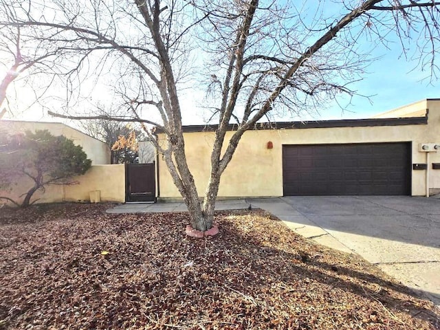 view of front of home featuring driveway, an attached garage, and stucco siding