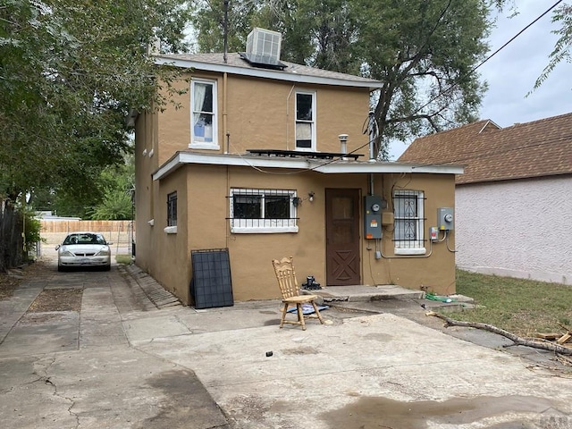 back of property featuring driveway, fence, a patio area, central AC, and stucco siding