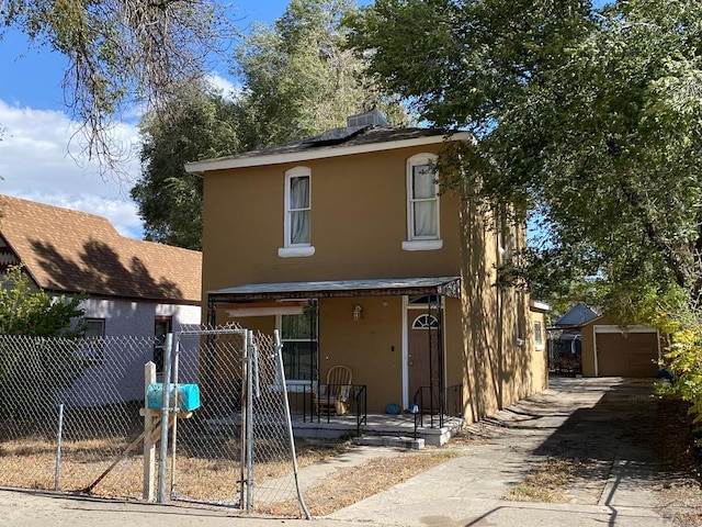 view of front of property featuring covered porch, fence, an outdoor structure, and stucco siding