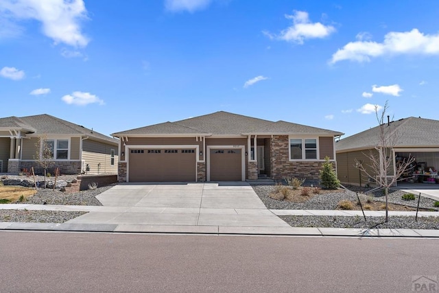 9257 Bugaboo Dr, Colorado Springs, CO 80920 - view of front of home featuring an attached garage, driveway, and stone siding
