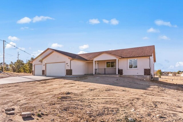 single story home featuring a garage, driveway, and stucco siding